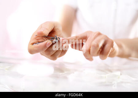 Ricostruzione unghie. Medicated ricostruzione unghie. La donna taglia le unghie manicure home.. Strumenti per manicure. Clipper o forbici?. Foto Stock