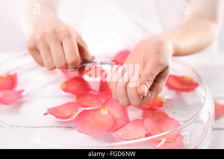 Tagliare le unghie, cura delle mani. Ricostruzione unghie. Medicated ricostruzione unghie. La donna taglia le unghie manicure home Foto Stock