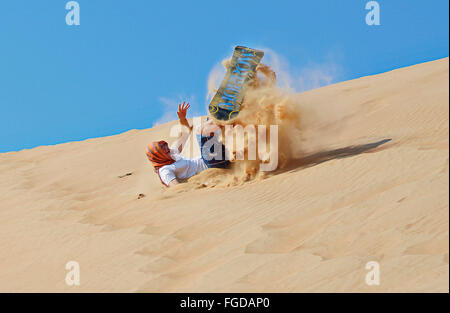 Sandboarding sulle dune di sabbia a Wahiba Sands, una delle più popolari destinazioni tourisit in Oman. Foto Stock