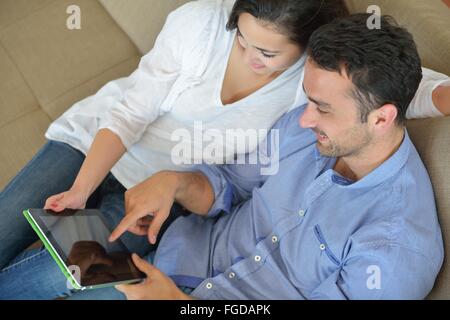 Paio di casa utilizzando computer tablet Foto Stock