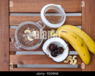 Cherry banana di noce di cocco per tutta la notte di avena con crepe aperte coco, banana, anacardi mescolati con semi di Chia e crema di ciliegio in un mason j Foto Stock