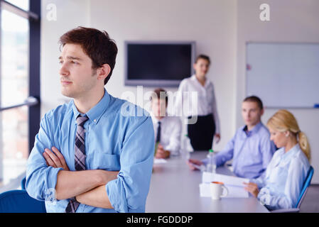 Uomo d'affari su una riunione in offce con colleghi in background Foto Stock