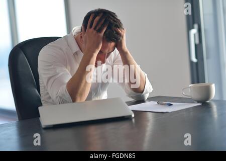 Frustrati azienda giovane uomo che lavora sul computer portatile a casa Foto Stock