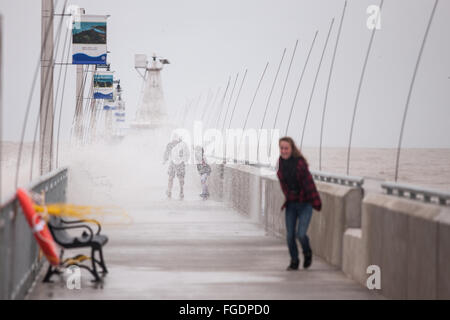 Port Stanley, Canada - Ottobre 3,2015. Onde infrangersi oltre il molo pubblico in Port Stanley come una famiglia cerca di rimanere a secco. Foto Stock