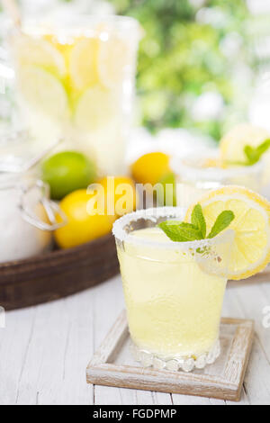 Rinfrescante limonata fatta in casa su un rustico tavolo esterno in condizioni di luce intensa. Foto Stock