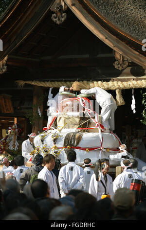 Gigante torta di riso viene scaricato per la sala Haiden Konomiya del santuario. Foto Stock