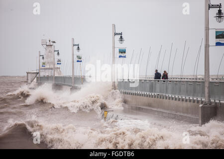 Port Stanley, Canada - Ottobre 3,2015. Onde infrangersi oltre il molo pubblico in Port Stanley, come un giovane cerca di rimanere a secco. Foto Stock