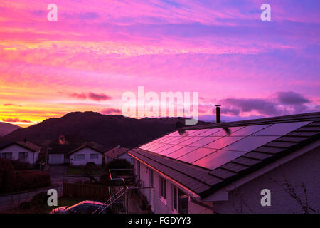 Tramonto su case sulla periferia di Ambleside, Lake District, Cumbria, Regno Unito, guardando verso Wetherlam con pannelli solari su un Foto Stock