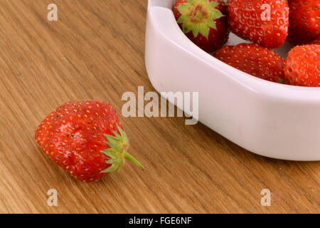 Fresche fragole mature su un annata sullo sfondo di legno Foto Stock