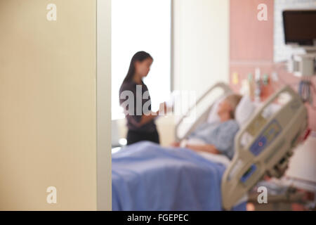 Focus sulla camera di ospedale segno con medico parlando al paziente Foto Stock