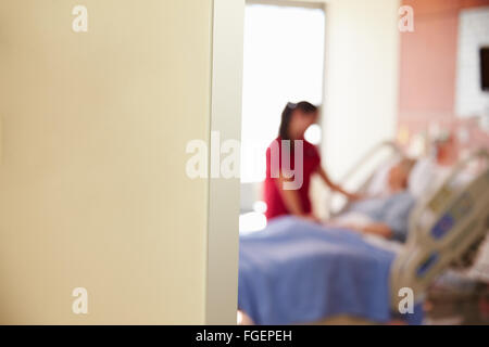 Focus sulla camera di ospedale segno con un infermiere parlando al paziente Foto Stock