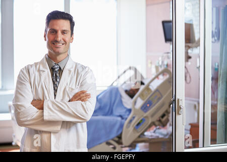 Ritratto maschile di medico con il paziente in background Foto Stock