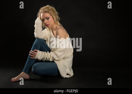 Giovane donna bionda in bianco maglione Foto Stock