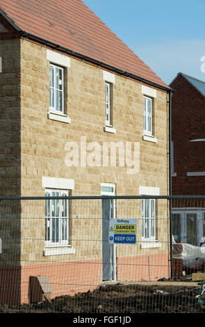 Salute e sicurezza pericolo tenere fuori segno sulla recinzione perimetrale di alloggiamento Bellway sito in costruzione, Bicester, Oxfordshire, Inghilterra Foto Stock