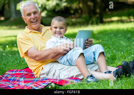 Nonno e il bambino in posizione di parcheggio utilizzando tablet Foto Stock