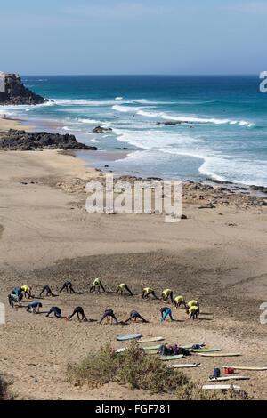 Foto aerea di un gruppo di surfers /scuola di surf facendo stretching e riscaldamento sulla spiaggia in FuerteventuraCanary Isole. Foto Stock