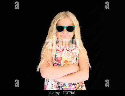 Ragazza giovane con capelli lunghi biondi indossando occhiali da sole, sorridente Foto Stock