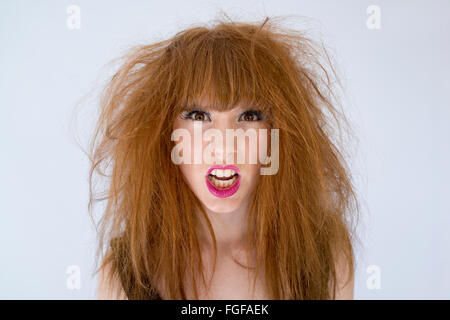 Ritratto di una donna con disordinati capelli disheveled con ed espressione della rabbia Foto Stock