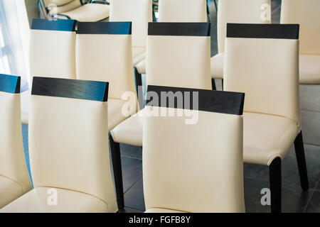 Sedie di pelle bianca in una sala per conferenze e convegni Foto Stock