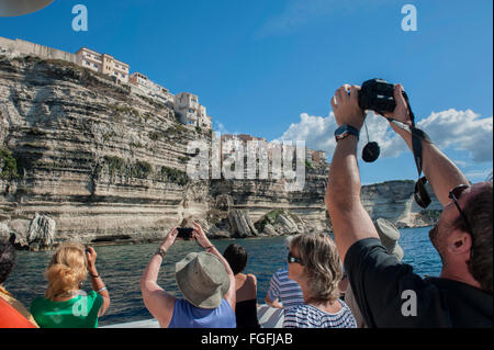 Fotocamera wielding i turisti a bordo di una barca per gite tour intorno a Bonifacio. La Corsica. Francia Foto Stock