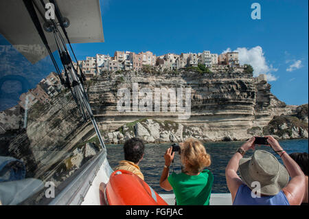 Fotocamera wielding i turisti a bordo di una barca per gite tour intorno a Bonifacio. La Corsica. Francia Foto Stock