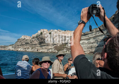 Fotocamera wielding i turisti a bordo di una barca per gite tour intorno a Bonifacio. La Corsica. Francia Foto Stock