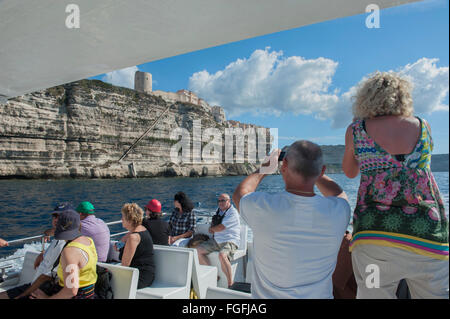 Fotocamera wielding i turisti a bordo di una barca per gite tour intorno a Bonifacio. La Corsica. Francia Foto Stock