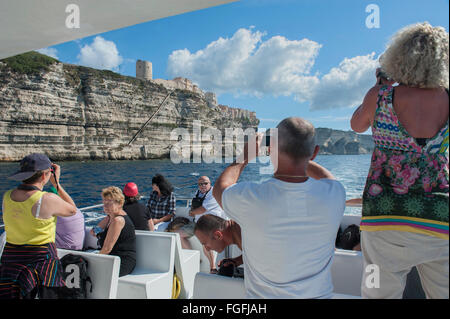 Fotocamera wielding turisti sul bordo di una gita in barca Gita intorno a Bonifacio Corsica Francia Foto Stock