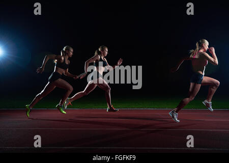 I corridori atletici passando il testimone nella staffetta Foto Stock