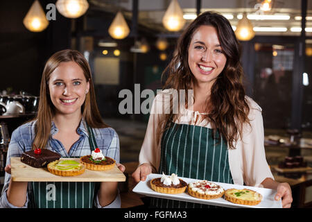 Sorridente baristi holding dessert Foto Stock