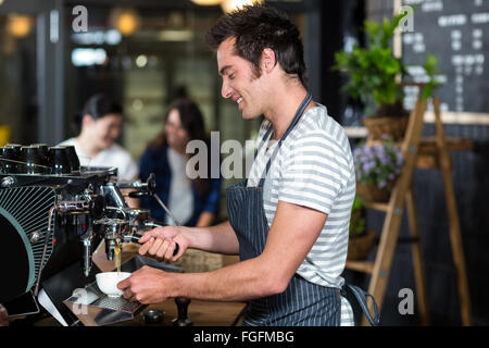 Sorridente barista bollitore per caffè Foto Stock