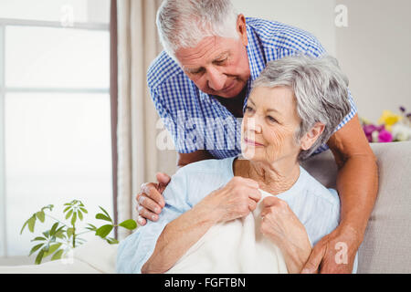 Senior uomo abbracciando la donna a casa Foto Stock