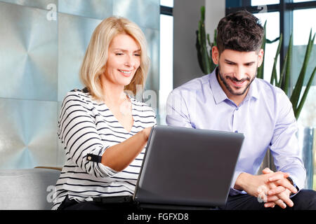 Portre di mezza età business donna seduta in ufficio con il giovane uomo di vendita e consulenza. La gente di affari analisi finanziaria d Foto Stock