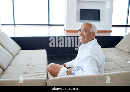 Ritratto di uomo senior in rilassante divano Foto Stock