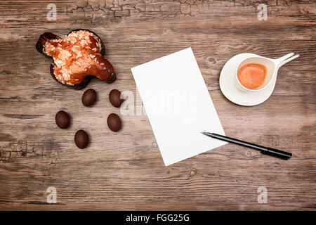 Colomba dessert, uova di cioccolato, caffè, carta e penna su legno Foto Stock