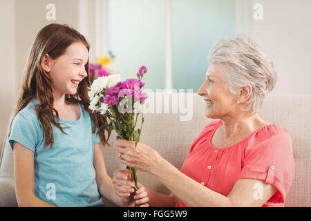 Nonna dando un mazzo di fiori per la sua nipote Foto Stock