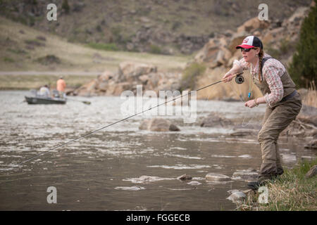 Una donna volare pesci dalla banca sulla Madison River in Montana. Foto Stock