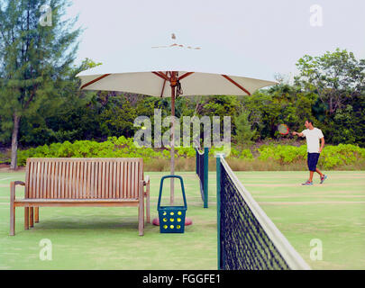 Un uomo gioca a tennis Parrot Cay Resort. Isole Turks e Caicos. Foto Stock