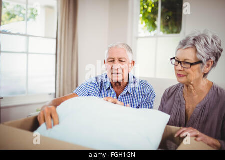 Coppia senior disimballaggio di una scatola di cartone Foto Stock