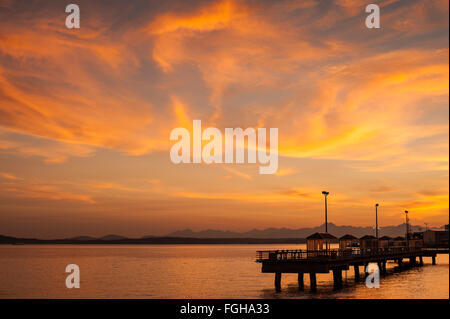 Drammatico tramonto sul Puget Sound e le montagne olimpiche con waterfront pesca del molo illuminato al crepuscolo, Seattle, Washington Foto Stock