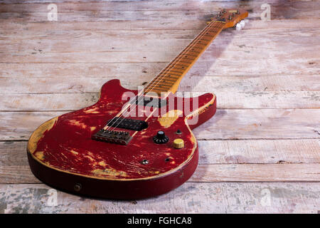 Vecchia chitarra elettrica retro rosso isolato su legno Foto Stock