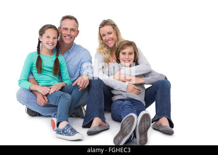 Ritratto di una famiglia sorridente seduto sul pavimento Foto Stock