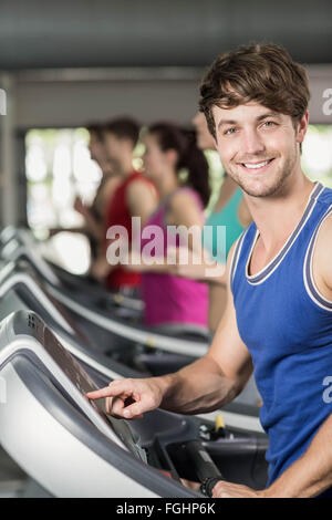 Sorridente uomo muscolare su tapis roulant Foto Stock