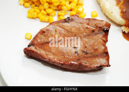 Bistecche servite su un piatto con i lati Foto Stock