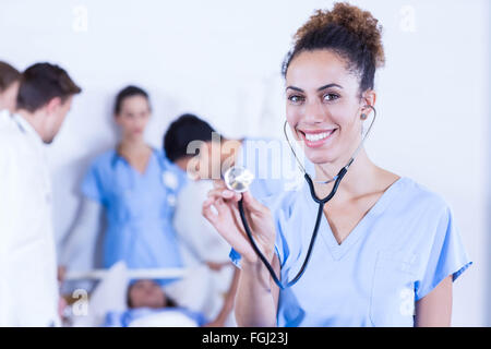 Medico donna che mostra uno stetoscopio verso la telecamera Foto Stock