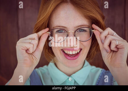 I capelli rossi hipster donna tenendo gli occhiali Foto Stock