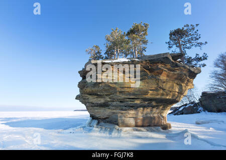 Questo stack del mare di roccia, noto come Rapa Rock, sorge dal ghiaccio di un lago ghiacciato Huron in inverno. Porto Austin Michigan Foto Stock