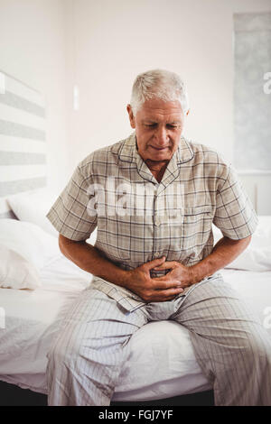 Malati senior man holding stomaco Foto Stock