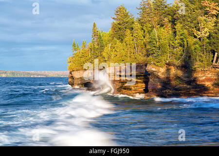 Onde infrangersi contro una costa rocciosa sul Lago Superior vicino Munising Michigan Foto Stock