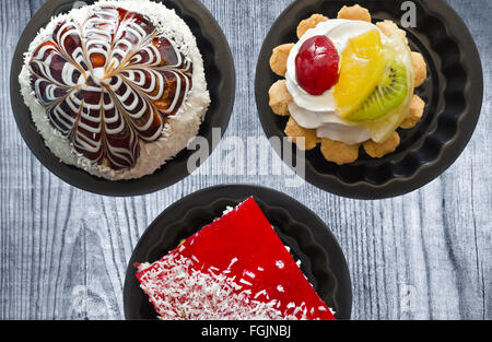 Torte in lattine sulla vecchia scheda. Foto Stock